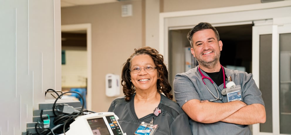 Two health care workers smiling into the camera