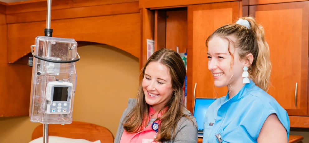 Two smiling nurses in a labor and delivery room