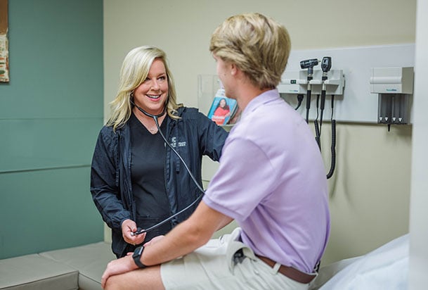 Nurse practitioner Amy O'Daniel examines a teen patient