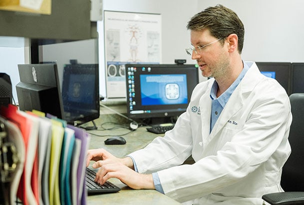 Doctor at computer typing in information