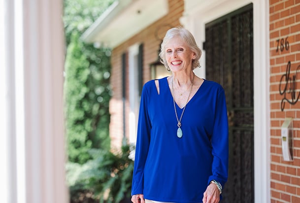 Silver-hair woman in blue walks away from her home