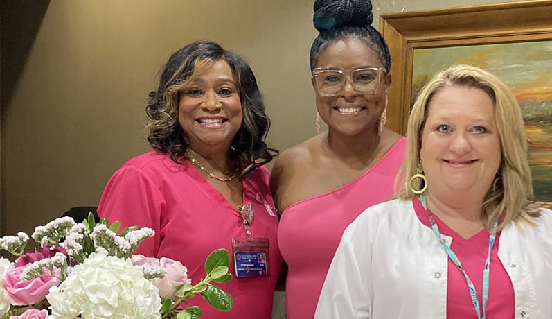 2023 Breast Cancer Advocate Award winner Katina Davis is flanked by with NMMC Cancer Care nurse navigators Stephanie Grove and Alison Christopher.