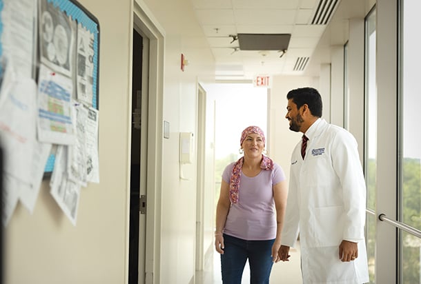 Breast cancer patient and doctor walking and talking in hallway