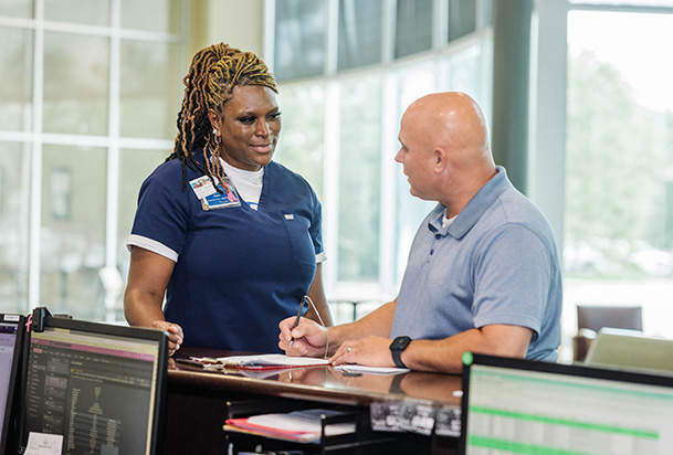 patient and doctor talking at the front desk