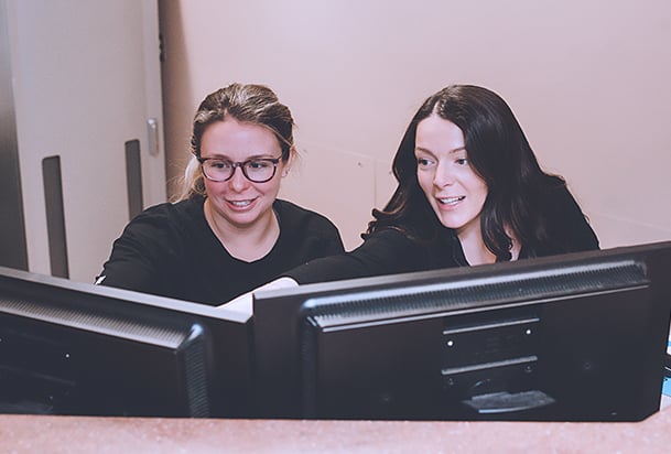 Two health care workers looking at computer screens
