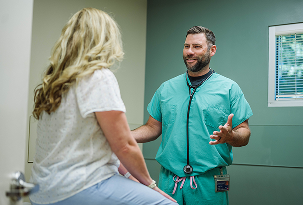 doctor talking to patient sitting on table