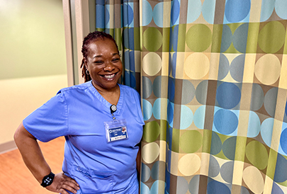 Nurse standing in front of a room separator curtain