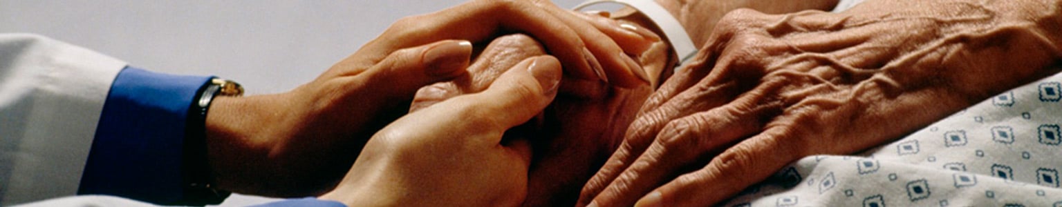 Caregiver holding patient's hand