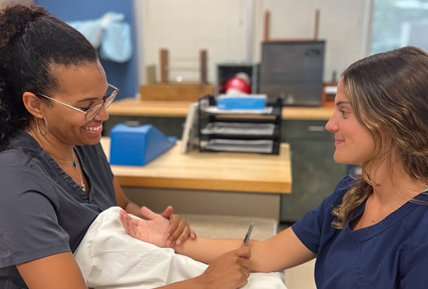 Occupational therapist doing hand therapy with female patient
