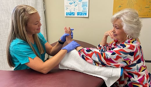 Occupational therapist doing hand therapy with female patient