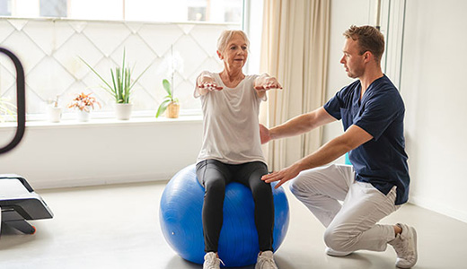 woman on exercise ball working with a trainer