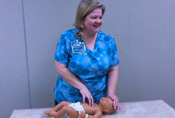 Educator demonstrating baby care