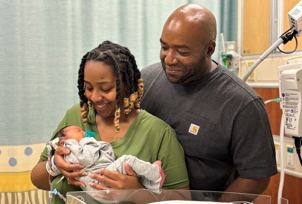 new parents holding their newborn in the NICU