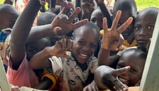 Ugandan children smiling and waving