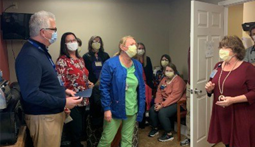 Employee of the Month Ashley Williams, center, is surprised by North Mississippi Medical Clinics president David Barber, right, and her Okolona Medical Clinic colleagues.