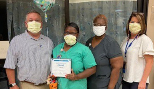 Kim Dun Darden group picture with plaque and balloon