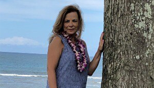 Rhonda Eaton on the beach with a flower necklace