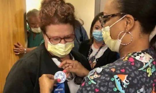 Dianne Gann being presented with a ribbon
