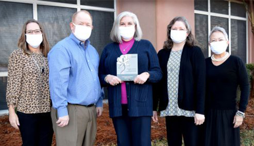 marketing crew group picture with face masks presenting award