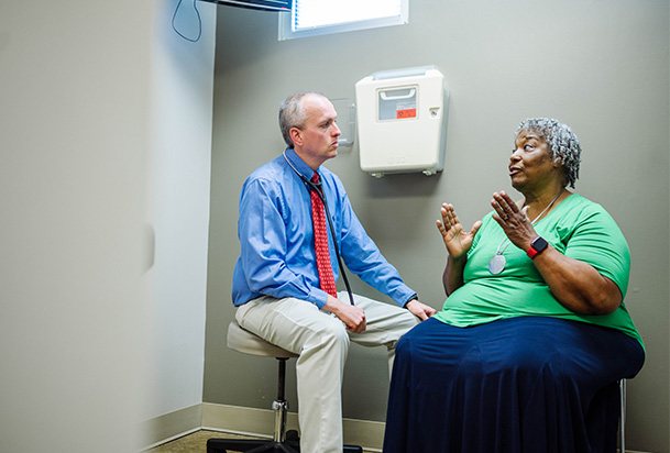 patient in a green shirt talking to her doctor