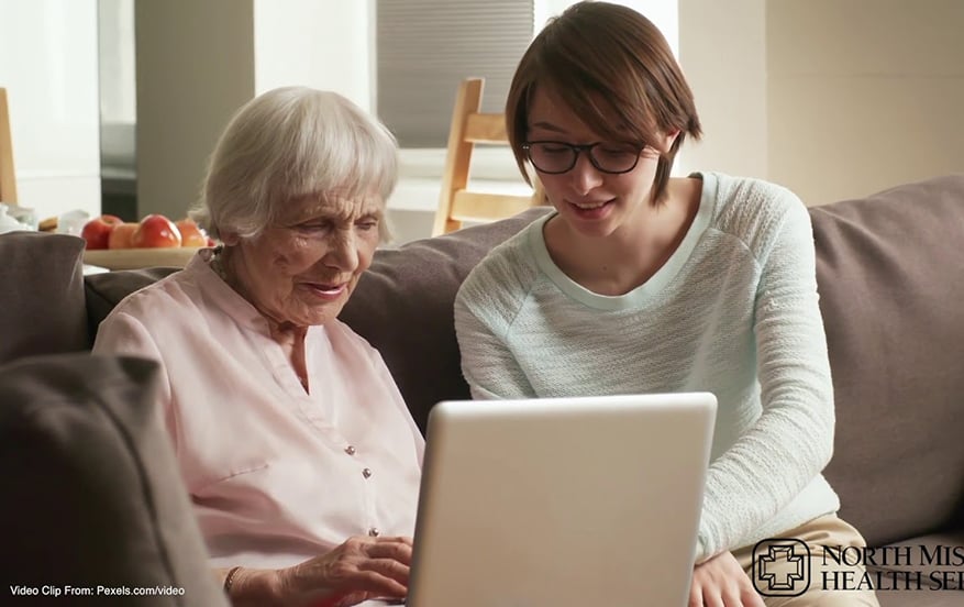 A young woman and older woman looking at a laptop together