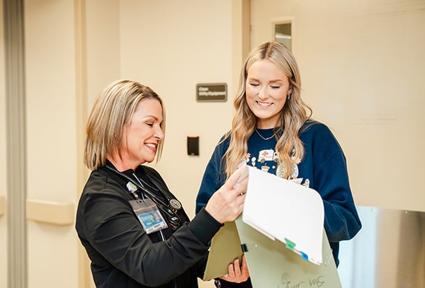 Two health care professionals review a medical chart
