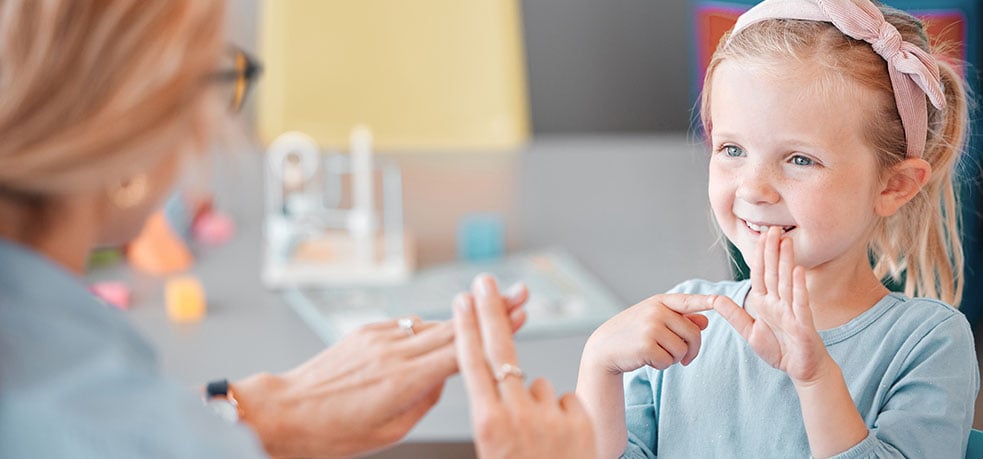 Young girl using sign language with older woman