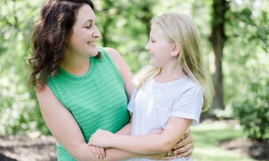 mother and daughter embracing and smiling at one another