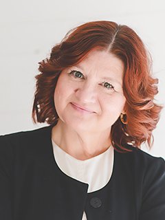 headshot of Angie Everett smiling, wearing a white shirt and black jacket