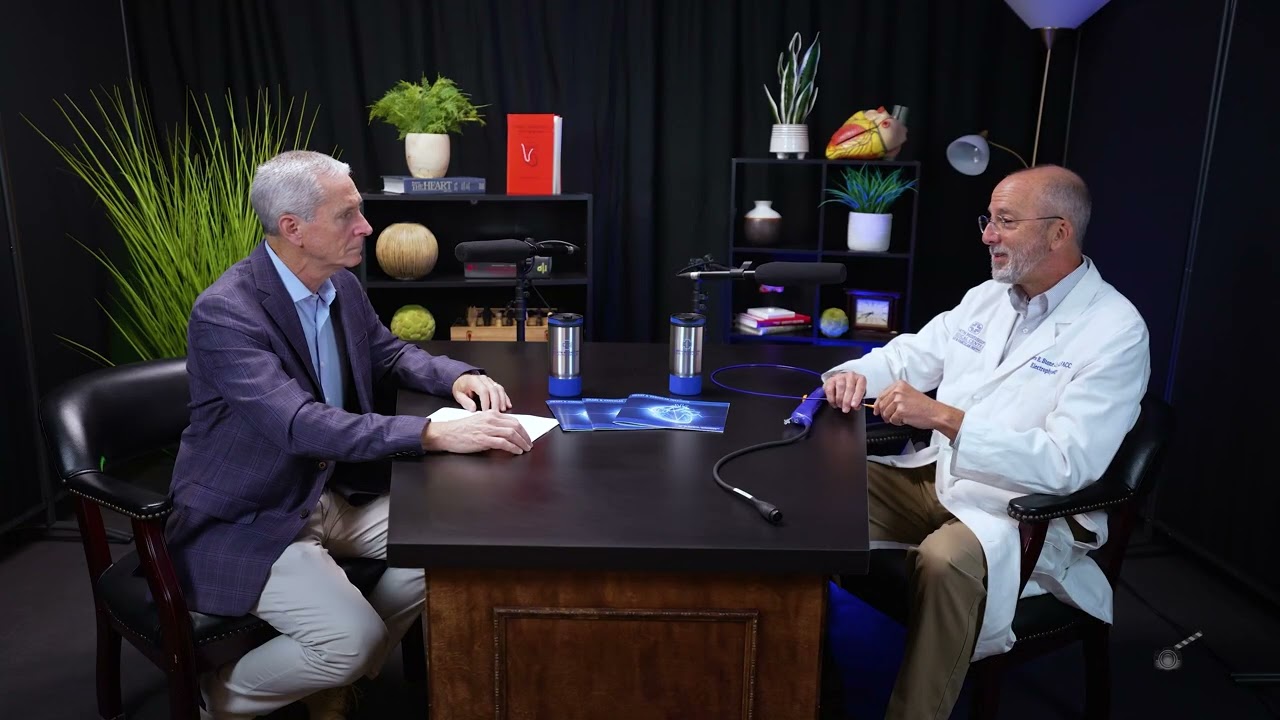 Dr. Bertolet and Stone sitting at a table with podcast microphones. 