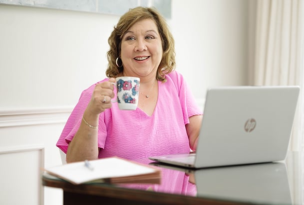 Woman on computer drinking coffee