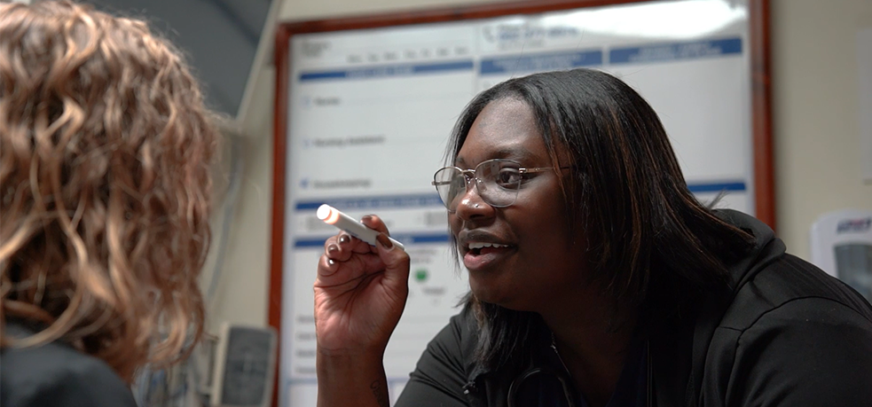 A nurse examining a patient using a pen light