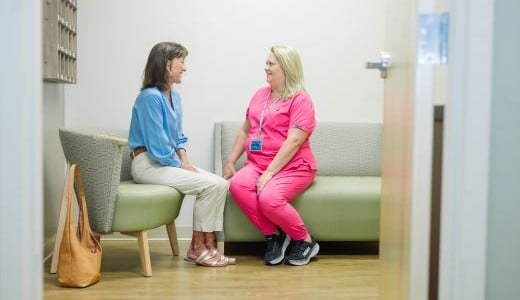 A woman talks with a member of the NMHS Cancer Care team