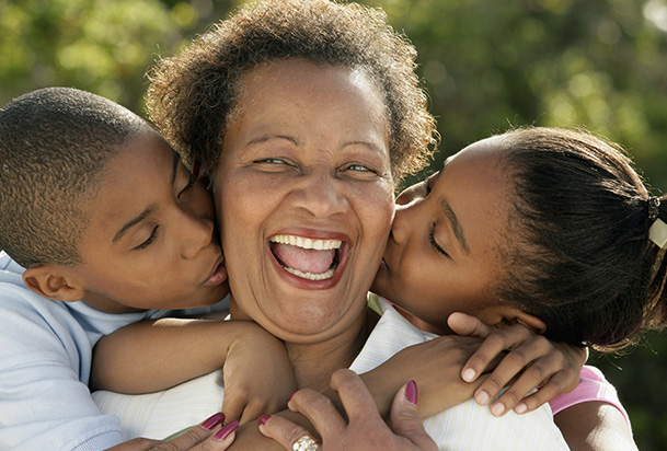 mom getting cheek kisses from her children