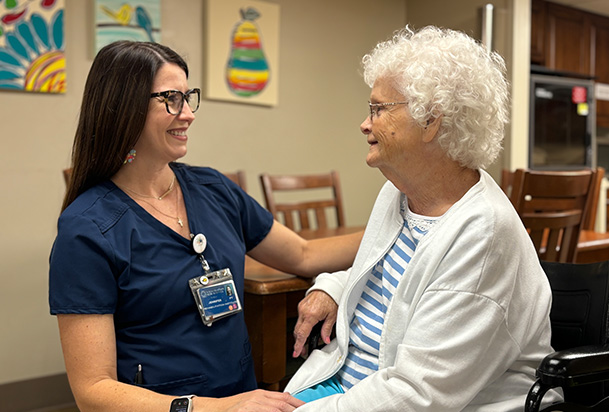 woman in a wheel chair talks to a health care provider