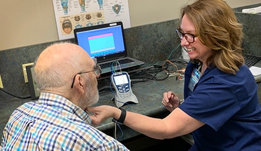 Speech therapist doing swallowing exercises with male patient