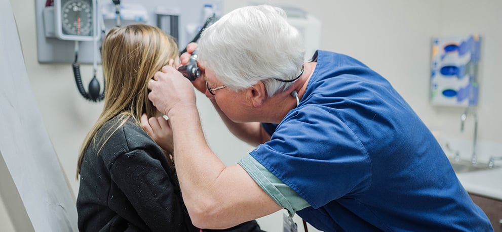 Doctor examining a young patient at an NMHS Urgent Care clinic