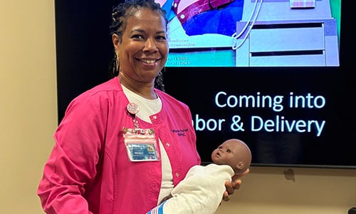 Health care professional holding a dummy baby