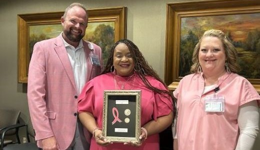 Shirlette Judon, center, is recognized as the NMHS Cancer Care Breast Cancer Advocate for 2025 by Daniel Lenard, NMHS vice president for oncology, radiology and pharmacy, left, and breast cancer nurse navigator Alison Christopher, right.