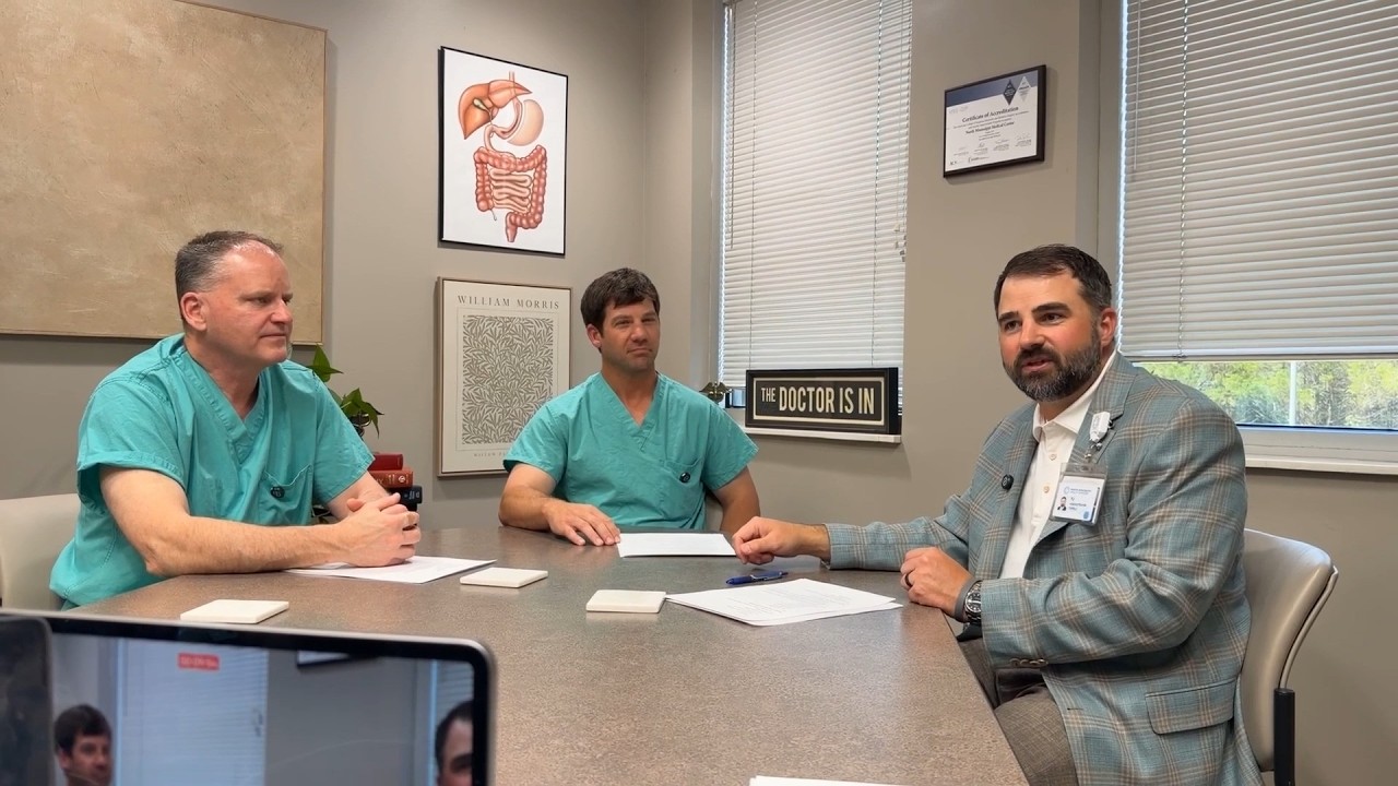 Drs. Pinson and Cauthen sitting at a table discussing weight loss surgery with TJ Adams. 