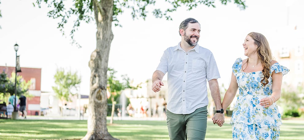 A couple holding hands and walking in a park