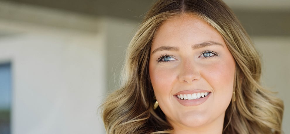 Young woman in a white shirt with long blonde hair outside of a medical clinic
