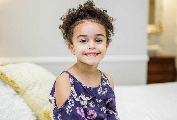 child smiling in a purple shirt