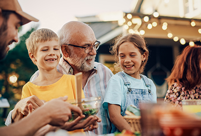 grandfather sitting with son and grandchildren outside