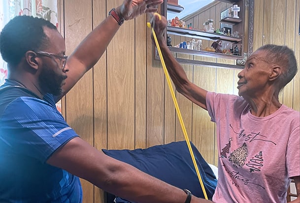 Home health rehabilitation therapist assists patient with exercises