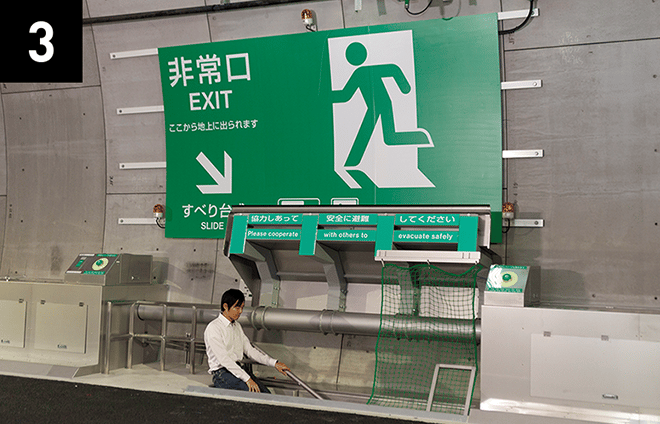 跳ね上げ扉が完全に開放されているのを確認し、すべり台で道路下の避難通路へ滑り降ります。