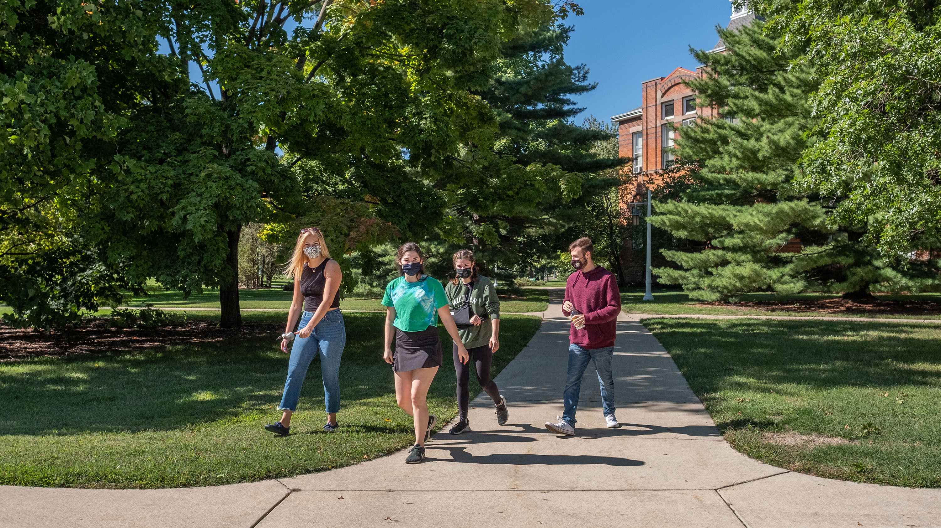 People in masks walking on campus