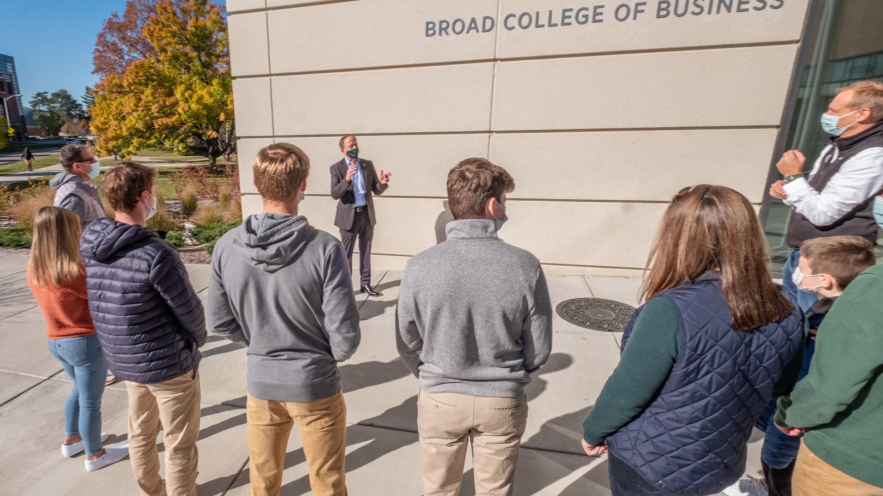 Prospective students listening to a tour in front of the business college