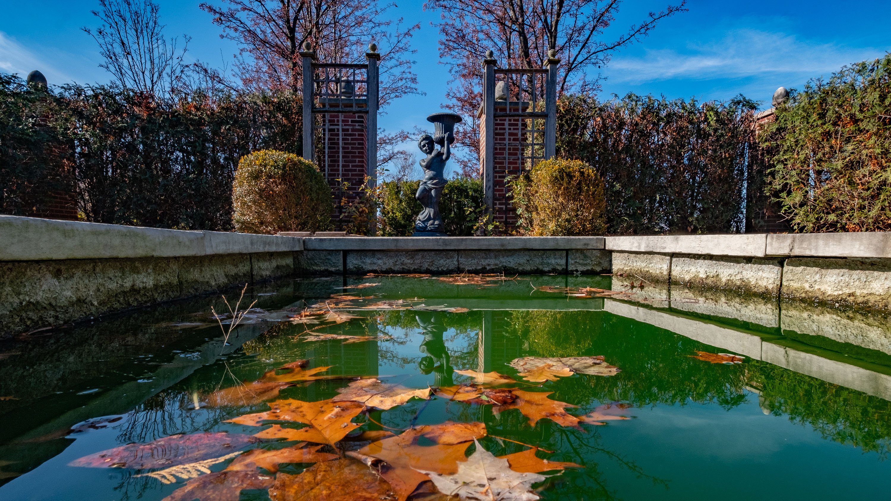 A statue overlooking a pond