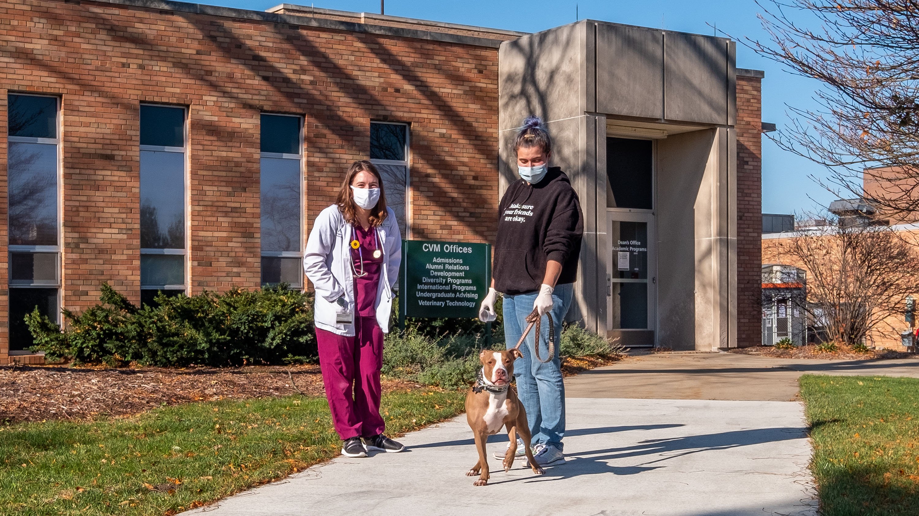 Veterinarian, client and patient standing outside the CVM offices.